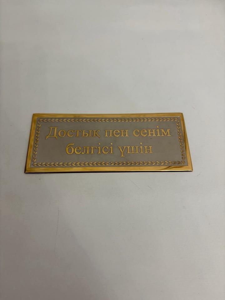 Гравированная металлическая табличка с дарственной надписью.