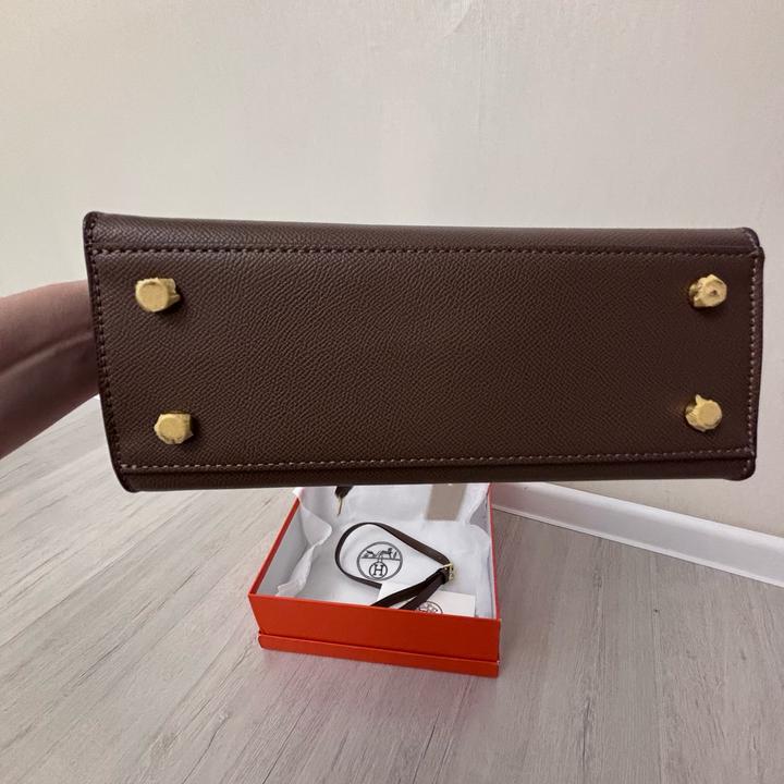 Стильная сумка Hermes коричневого цвета с золотистой фурнитурой.