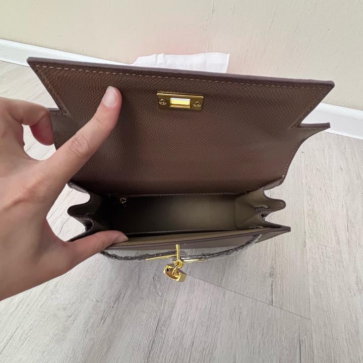 Стильная сумка Hermes коричневого цвета с золотистой фурнитурой.
