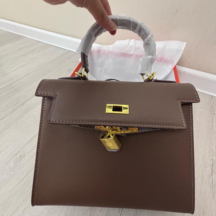 Стильная сумка Hermes коричневого цвета с золотистой фурнитурой.
