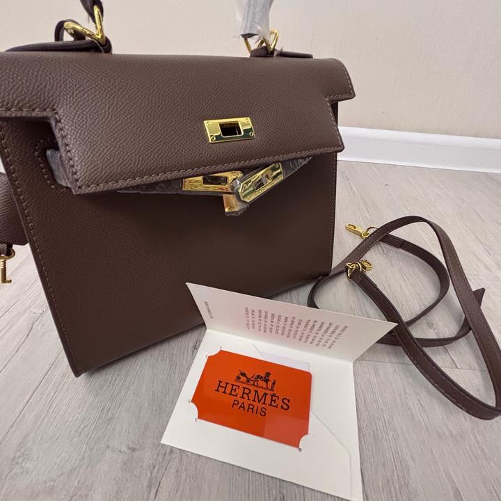 Стильная сумка Hermes коричневого цвета с золотистой фурнитурой.