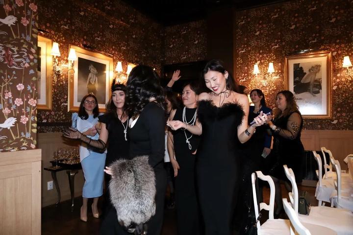 Черное бандажное платье с перьями облегает фигуру делая ее точенным тянется