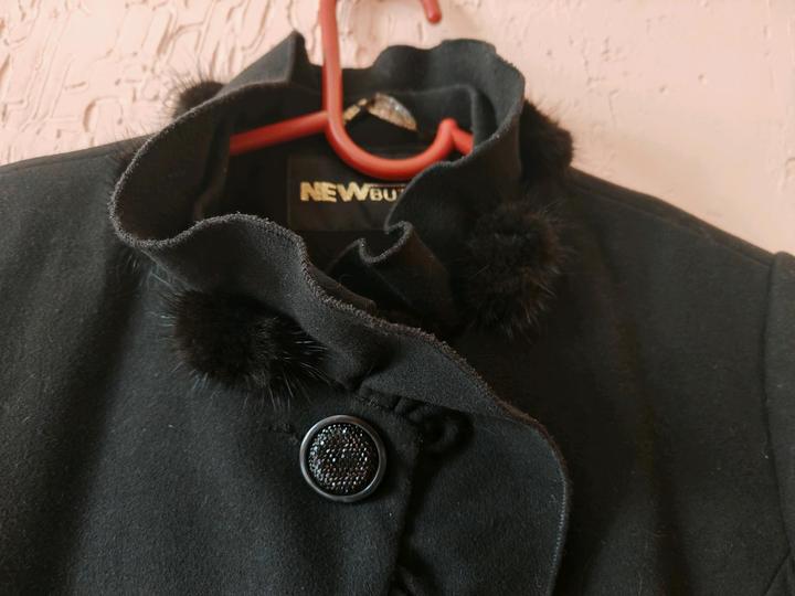 Пальто украшено мехом норки