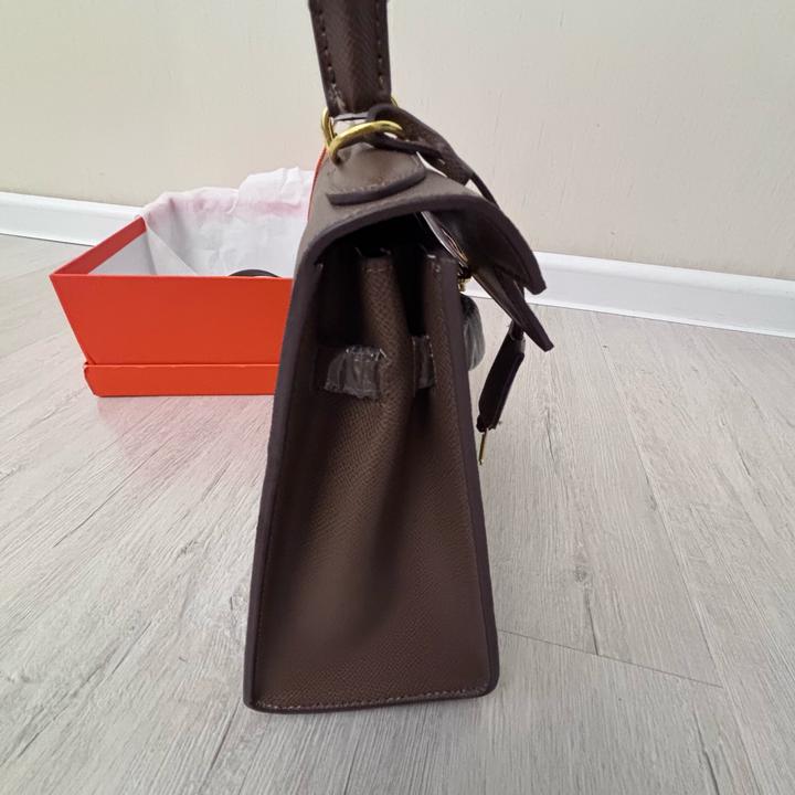 Стильная сумка Hermes коричневого цвета с золотистой фурнитурой.