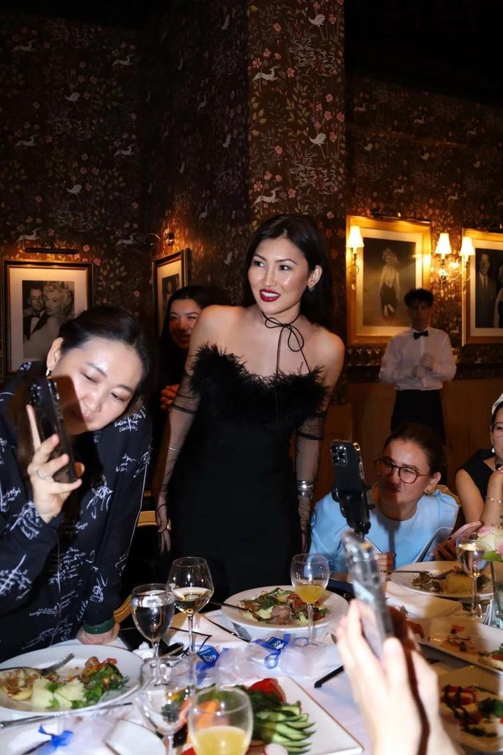 Черное бандажное платье с перьями облегает фигуру делая ее точенным тянется