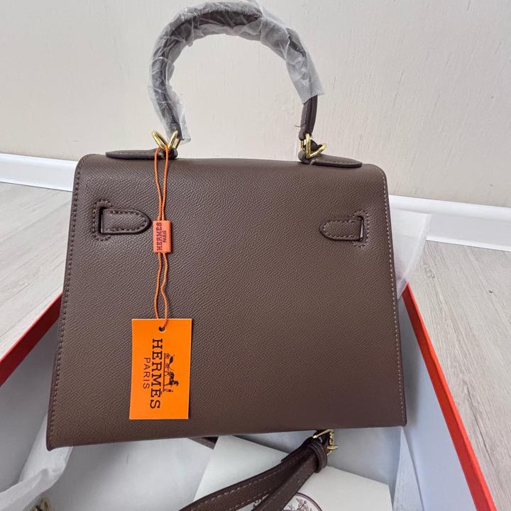 Стильная сумка Hermes коричневого цвета с золотистой фурнитурой.