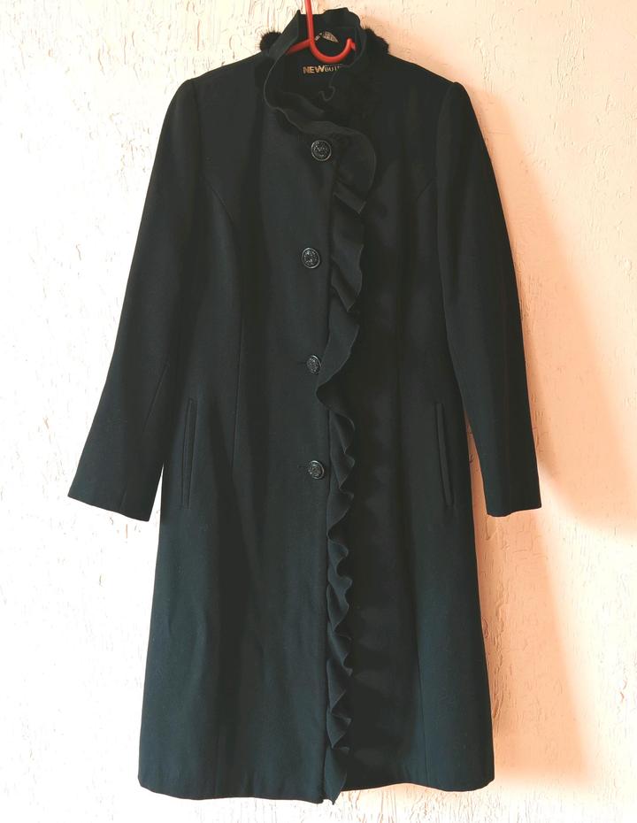 Пальто украшено мехом норки